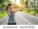 Small photo of Fitness woman doing stretch exercise stretching her arms - tricep and shoulders stretch wearing a smartwatch activity tracker. Women stretching for warming up before running or working out.