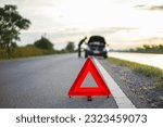 Small photo of red emergency stop sign with broken down car on the road waiting to be repaired. Close-up of red emergency stop sign placed on the road for vehicle accidents or breakdowns for road safety.