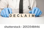 Small photo of Doctor holds wooden cubes in his hands with text declaim