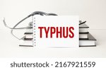 Small photo of typhus word on white notebook with stethoscope