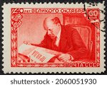 Small photo of A postage stamp printed in the USSR depicts Vladimir Lenin Ulyanov reading the Pravda newspaper, 40th anniversary of the Great October Revolution, Lenin Series, circa 1957.