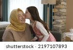 Small photo of Istanbul,Turkey -22.04.2022:Girl offering candy to her grandmother to celebrate Eid al-Fitr traditionally after the end of the holy month.Girl kisses her grandmother on the cheek to show respect.