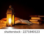 Small photo of Islamic concept - The Holy Al Quran with written Arabic calligraphy meaning of Al Quran and a beautiful Arabian lamp, Arabic word translation : The Holy Al Quran (holy book of Muslim)