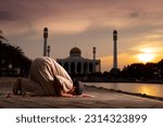 Small photo of A little Asian Muslim boy is praying with peace in the beautiful mosque, giving a powerful atmosphere of faith, with copy space, islam concept.