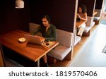 Small photo of Businesswomen Working In Socially Distanced Cubicles In Modern Office During Health Pandemic