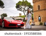 A girl in a dress next to a sports car on a city street in Tuscany.Italy.