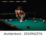 A girl in a hat in a billiard...