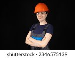 A woman in a protective helmet, glasses and overalls on a black background with space for text.