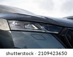 Angled view on headlight of new gray metallic car model  with Matrix Full Led technology, visible washer cover and gloss black grille frame