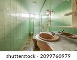 Small photo of Toilet with kitsch vintage tiles and floors in shades of green and brown.