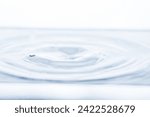 Small photo of An indentation after a drop falls into water on a white background