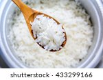 Cooked rice in pot with wood spoon