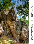 Small photo of Ancient Thracian rock sanctuary "Deaf stones" (Gluhite kamani) in the southern Rhodopes, Bulgaria -A huge rock among the trees Thracian trapezoidal niches