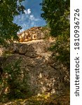 Small photo of Ancient Thracian rock sanctuary "Deaf stones" (Gluhite kamani) in the southern Rhodopes, Bulgaria - A huge rock among the trees Thracian trapezoidal niches