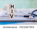 Small photo of The word HIV is written on wooden cubes near a stethoscope on a paper background. HIV - short for Human Immunodeficiency Virus. Medical concept.