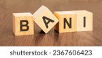 Small photo of wooden blocks with word BANI on dark wooden background. Brittle Anxious Nonlinear Incomprehensible concept