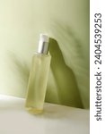 Small photo of Light green transparent skin care product lotion press against the wall to lengthen the shadow