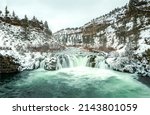 River waterfall among snowy...