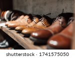 Men's shoe boutique. Brown leather men's shoes stand in a row on a store shelf. Brown Men's Derby in a Store Window