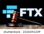 Small photo of Kazan, Russia - Nov 14, 2022: FTX is cryptocurrency exchange. Gavel on table against background of FTX logo. The concept of trial.