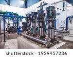 Small photo of Industrial interior of water pump, valves, pressure gauges, motors inside engine room. Valve and pumps in an industrial room. Urban modern powerful pipelines and pumps, automatic control systems