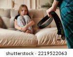 Small photo of Mother wants to punish her child daughter with belt in hand. Angry mom punishes teen girl for offense and hits baby with belt. Concept of family quarrels, problems and parenting. Copy text space