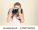 Small photo of pretty young girl holding old camera, girl make a pretence of taking photos, banner copy space