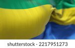 Small photo of Close-up view of the Gabon national flag waving in the wind. The Gabonese Republic is a Central African Country. Fabric textured background. Selective focus