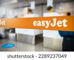 Small photo of London, UK Jan 2023: Orange retractable belt barrier with the Easyjet logo inside an airport. Easyjet is a British multinational low-cost airline. Travel and airport security. Illustrative editorial