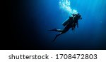 Woman scuba diving in deep blue ...