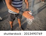 Portrait of an athlete's hands applying weightlifting Chalk Powder for training with weights - sportsman using equipment during training concept
