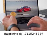 Small photo of New York, United States, 30th January 2022: A man considers buying a tesla by paying with Bitcoins. Tesla allows you to buy products with cryptocurrencies.