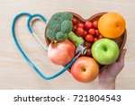Cholesterol diet, diabetes control and healthy food nutritional eating for cardiovascular disease risk reduction concept with clean fruits in heart dish with nutritionist monitoring conceptual idea