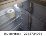 Empty Refrigerator. Toilet Paper in an Empty Refrigerator. White Open Refrigerator. The Concept of a Diet for Weight Loss.