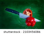 Sharp knife slicing pepper in mid air
