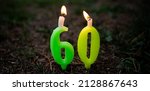 Small photo of Candles with the number 60 are burning stuck in the ground. The sixtieth anniversary.