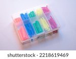 Small photo of heat shrink tubing for wire shielding. Tubes of different colors shrink from heating. Soldering of wires. Attachments for the shareholder in a transparent box.