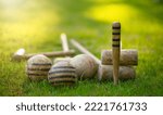 Small photo of An antique set for playing croquet on the green grass. Wooden clubs with striped balls. Victorian outdoor games.