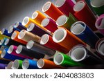 Small photo of Rolls of multicolored vinyl film for detaling and car tuning. Sale of self-adhesive film from a warehouse. Color selection in the design.