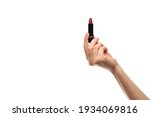 Red lipstick in a woman's hand on a white background, isolated.