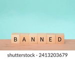 Small photo of Wooden block with text BANNED. A ban refers to a formal or official prohibition or restriction on a particular activity, action, item, or person. It is an authoritative decision made by a government
