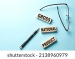Small photo of GNP Gross Domestic Product text on wooden block ,blue background