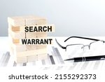 Small photo of SEARCH WARRANT is written on a wooden blocks on a chart background