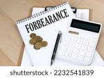 Small photo of FORBEARANCE text on notebook with chart and calculator and coins, business concept