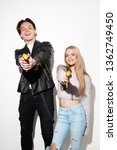 Small photo of Smash outright. Close up fashion portrait of two young cool hipster girl and boy wearing jeans wear. Studio shot of two models having fun and making serious faces.