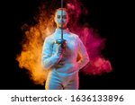 Small photo of Historical time. Teen girl in fencing costume with sword in hand isolated on black background, neon lighted smoke. Practicing and training in motion, action. Copyspace. Sport, youth, healthy lifestyle