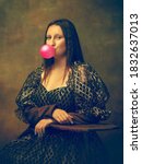 Small photo of Bubble gum. Young woman as Mona Lisa, La Gioconda isolated on dark green background. Retro style, comparison of eras concept. Beautiful female model like classic historical character, old-fashioned.