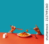 Small photo of Food pop art photography. Female hands tasting spaghetti with meatballs on plaid tablecloth isolated on bright blue background. Vintage, retro style interior. Complementary colors, Copy space for ad