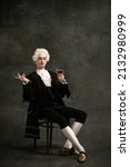 Small photo of Handsome man in image of medieval person, aristocrat tasting wine isolated on dark green vintage background. Retro style, comparison of eras concept. Elegant male model as historical character