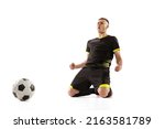 Winner emotions. Goal. Professional male soccer player in black football kit posing with ball isolated on white studio background. Concept of sport, competition, male hobby, occupations.